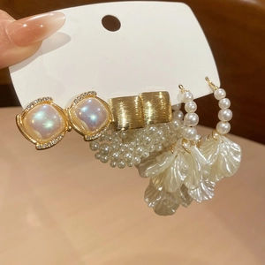 Detail view of pearl and floral drop earrings set with crystals on display card