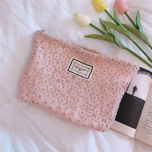 Detailed embroidery on pink daisy lace pouch featuring a Time To Party woven label
