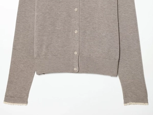 Detail of taupe knit cardigan showing buttons, ribbed hem, and lace-trimmed sleeve cuffs