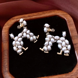 Macro detail of vintage poodle earrings with pearls and crystals in a jewelry box