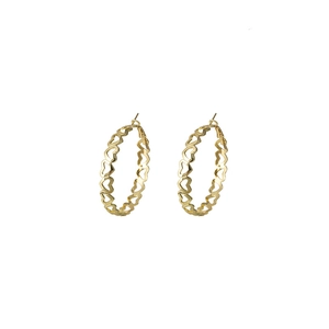 Close-up of golden C-shaped hoop earrings with intricate hollow heart-shaped pattern detail