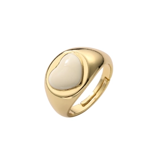 Detailed view of heart-shaped gold ring with white enamel and widening adjustable band