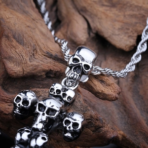 Silver skull anchor pendant with punk design on a textured wood background