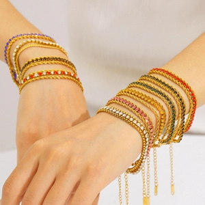 Bracelets empilables en zircon multicolore plaqué or portés sur fond blanc neutre