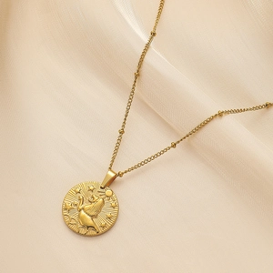 Macro shot of gold coin pendant with Leo zodiac relief and sun star details on silk