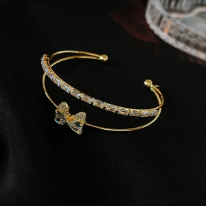 Detail of a gold-plated double-layer bracelet featuring zircons and a bow knot