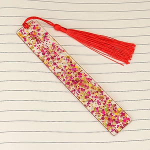 Handmade clear acrylic bookmark with shiny red and gold sequins and a red tassel charm