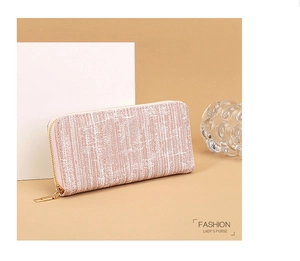 Detail view of pink-beige striped long wallet featuring a stylish gold zipper closure