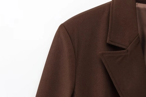Detail of a brown blazer featuring twill fabric texture and notched lapel craftsmanship