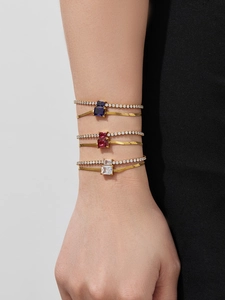 Detailed view of layered 18k gold plated bracelets with zircon stones in various colors