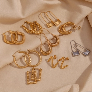 Minimalist geometric 18K gold and silver plated stainless steel earring set on beige fabric