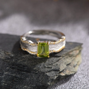 Macro detail of rectangle peridot silver ring with hammered texture and gold borders