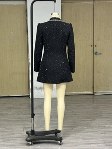 Detail view of the back of a black sequined party dress with silver sparkle finish