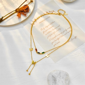 Double-layered 18K gold butterfly necklace with colored gems and tassel accents