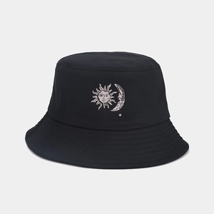 Dettaglio del ricamo sole e luna su un classico cappello a secchiello nero in cotone
