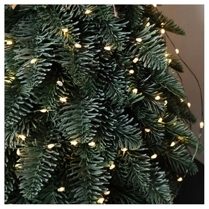 Macro shot of warm white LED lights on artificial pine needles for Christmas decoration