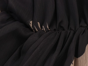 Macro view of brushstroke print chiffon fabric showing pleated texture and soft wrinkles