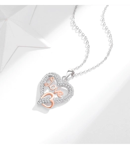 Detail of silver and rose gold heart necklace with white zircons and 'love' engraving