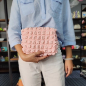 Close-up of pink bubble textured cosmetic bag featuring soft quilted fabric and zipper