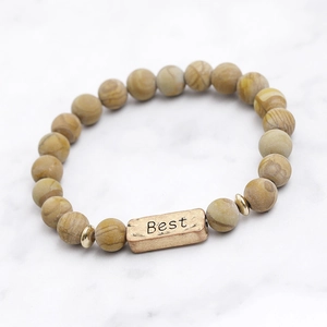 Detail van yoga-armband met kralen van lavasteen en gegraveerde Best metalen tag