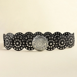 Dettaglio cintura vintage in pelle nera con fibbie in metallo argentato e incisioni floreali