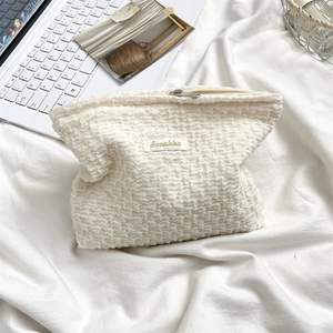 Close-up of white bubble texture makeup bag with silver zipper and Sozakka brand label