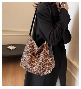 Detail of leopard print tote bag with black strap showing spacious canvas interior