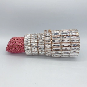 Detail of crystal segments and pink rhinestones on a lipstick shaped evening clutch bag