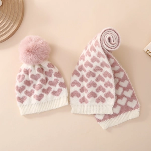 Detail von Baby-Strickset aus Mütze und Schal mit Herzen und weichem Bommel