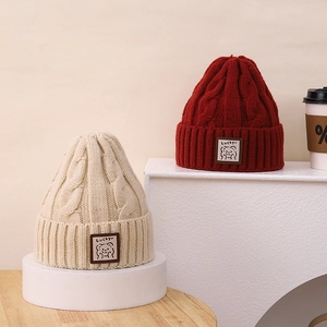 Detailed knit texture and cute bear patch on cream and red winter beanies
