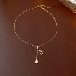 Détail du collier en acier inoxydable doré avec double pendentif gourde et cristaux