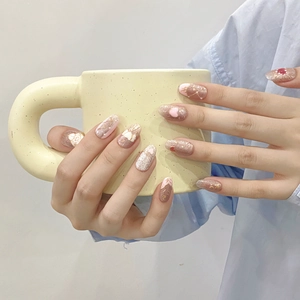 Pink and brown handmade press-on nails with glitter, gold lines and heart accents