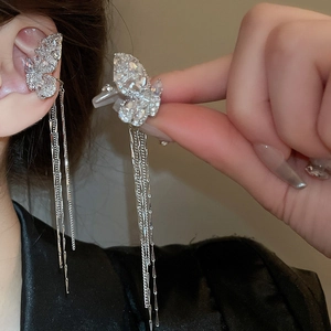 Close-up of silver butterfly ear cuff with zircon tassels and elegant fringed chain detail