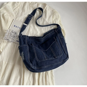 Détail du sac cabas en jean avec bords effilochés et bandoulière réglable