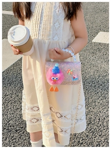 Close-up of pink sequined girls bag featuring pearl handle and cute plush chick decor