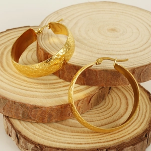 Textured 18K gold plated stainless steel chunky hoop earrings on natural wooden display