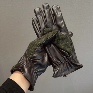 Close-up of leather and green herringbone wool gloves with elastic wrists on model