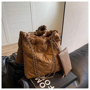 Dettaglio borsa a tracolla trapuntata marrone con catena e pochette coordinata