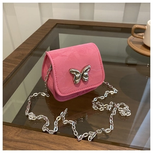 Detail of pink PU leather crossbody bag featuring silver butterfly and chain strap