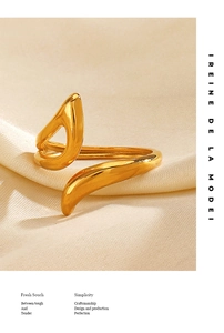 Detailed macro shot of a polished gold geometric ring resting on beige silk fabric