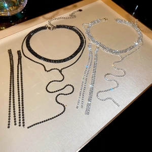 Detailansicht der funkelnden Strasshalskette und Fransenohrringe in Schwarz und Silber