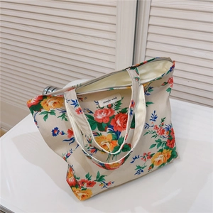 Detail of floral cotton tote bag showing secure zipper closure and simple wish interior label