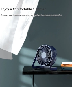 Mini navy blue USB desk fan with circular grille on marble table, compact and quiet