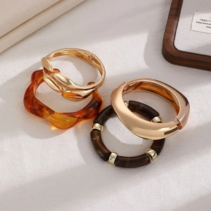 Detail of four-piece bracelet set with gold metal, amber resin, and tortoiseshell beads