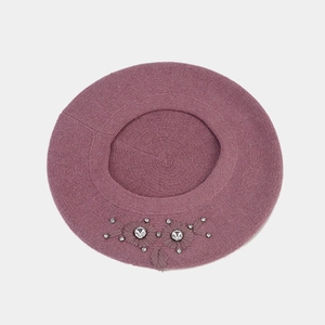 Detail of purple knitted beret featuring floral embroidery with rhinestones and beads