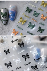 Macrodetail van 3D-reliëf nagelstickers met strikjes en artistieke typografie