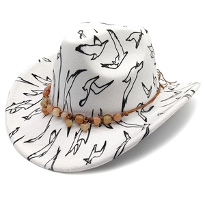 Detail of white wool jazz hat featuring black bird patterns and beaded heart pendant