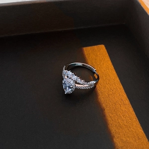 Macro view of water drop zircon ring with crown setting in a dark jewelry box