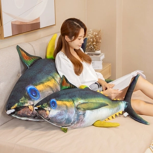Detailed view of two tuna plush pillows used as backrests in a cozy bedroom setting