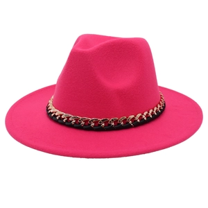 Detail of rose red fedora hat with gold metal chain and black woven band decoration